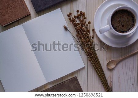 blank notebook on wooden desk with coffee cup 