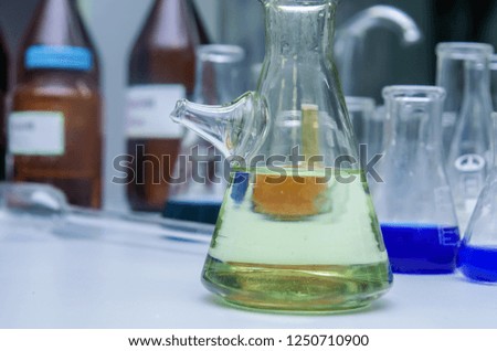A glass in a chemical laboratory, glass in green light, chemical science photo illustration, chemical experiment with liquid i glass, medical experiment in laboratory, glowing glass with chemical