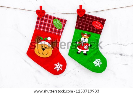 Decorative christmas socks. Empty socks for gift hanging off a thread on white stone background top view