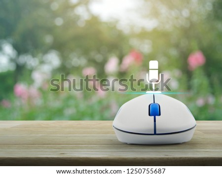 Microphone flat icon with wireless computer mouse on wooden table over blur pink flower and tree in park, Business communication online concept