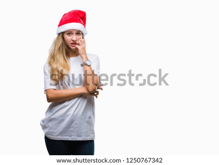 Young beautiful blonde woman wearing christmas hat over isolated background looking stressed and nervous with hands on mouth biting nails. Anxiety problem.