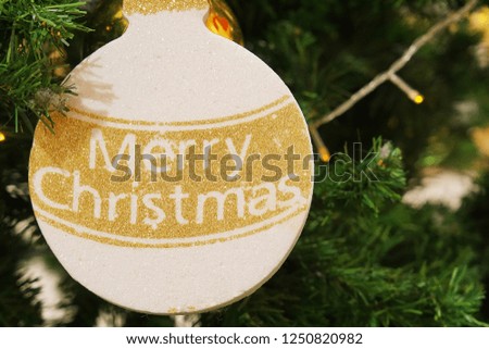 Christmas Trees & Decorations. A word Merry Christmas banner hanging from Christmas tree.