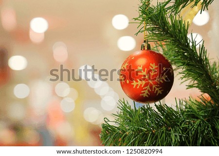 Christmas Trees & Decorations. Red bauble hanging from Christmas tree with bokeh background.