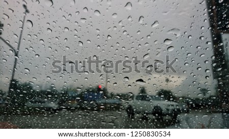 Rainy day through raindrops on a car window. Selective focus. 