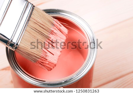 Brush with Living Coral paint on wooden background. Color of the year 2019. Main trend concept.