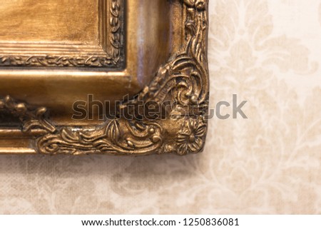 Gilded frame. Old picture. Expensive vintage mirror. Crack on an antique frame. Rare decor in the design of a luxurious interior. Restoration of a frame with an ornament.