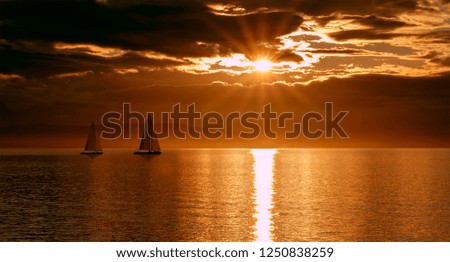 Two boats sailing the sea during sunset, romance for any publishing needs