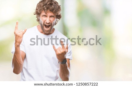 Handsome hispanic model man over isolated background shouting with crazy expression doing rock symbol with hands up. Music star. Heavy concept.
