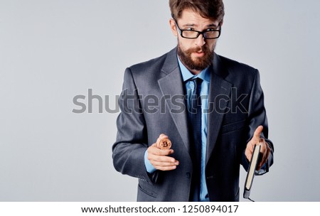 A business man in a suit holds a coin in his hand and looks away                        