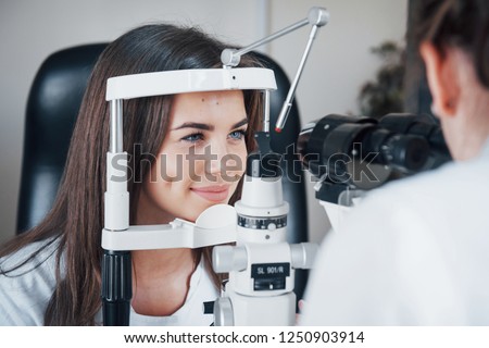 Optometrist checking vision of young beautiful woman. Royalty-Free Stock Photo #1250903914