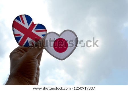 Hand holds a heart Shape United Kingdom and Japan flag, love between two countries
