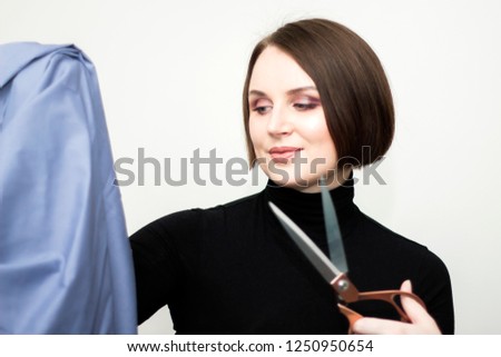 Smiling Portrait of happy seamstress holding scissors