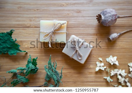 Organic handmade soap making, spa treatments, skin care. Spa soap bars with natural ingredients.  Dried herbs, oats and rose blossoms on wooden vintage background. Instagram style, top view photos. Royalty-Free Stock Photo #1250955787