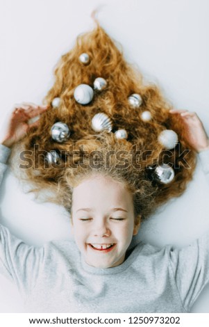 Christmas Winter Happy Girl. Beautiful New Year and Christmas Tree Holiday Hairstyle. Beauty Fashion Model Girl on a grey Background. Creative Hair style decorated with Christmas balls