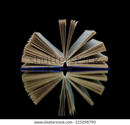 open book with reflection on black background