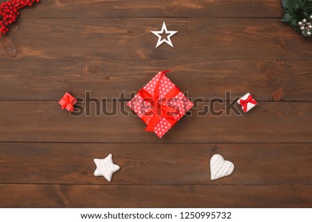 New year theme red gift box surrounded with decorations isolated on wooden table top view close-up