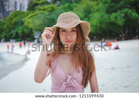 Beautiful woman holding a hat on the beach. 