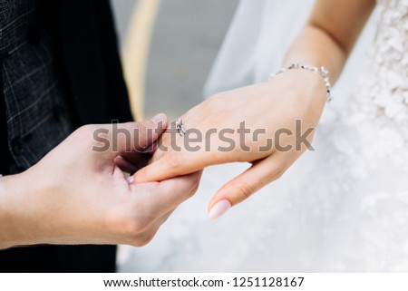 groom holds the hand of the bride with a wedding ring