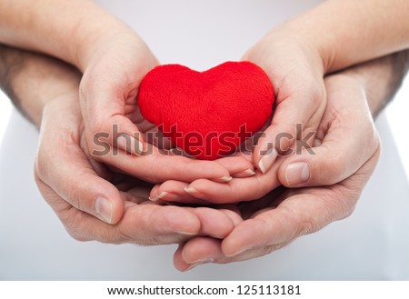 Couple in love holding a red heart in their hands