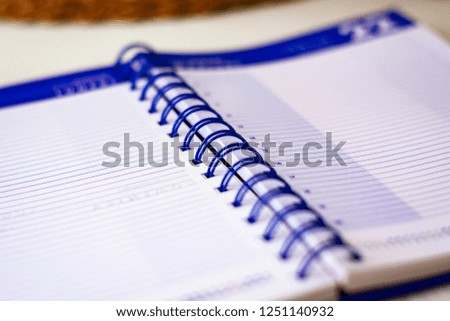 Open spiral notebook with lined sheets to write important appointments of the day. Business and productivity concept. Stationery object.