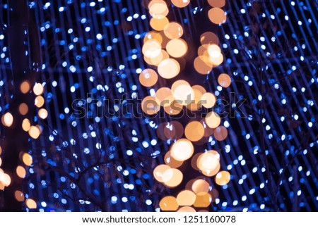 Decorative outdoor string lights hanging on tree at night time. Christmas tree bokeh background.