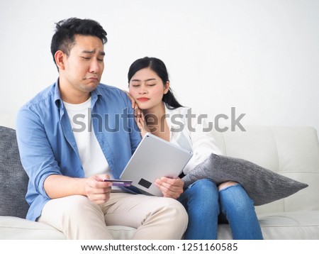 Happy Asian couple lover using laptop together for shopping online at home.