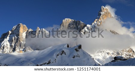 Beautiful panorama at Passo Rolle in the italian Dolomites. Winter season, Mount Cimon della Pala, mountains group Pale di San Martino in the fog, Northern Italy, Europe.