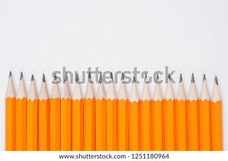 orange pencils with graphite rods on a white background