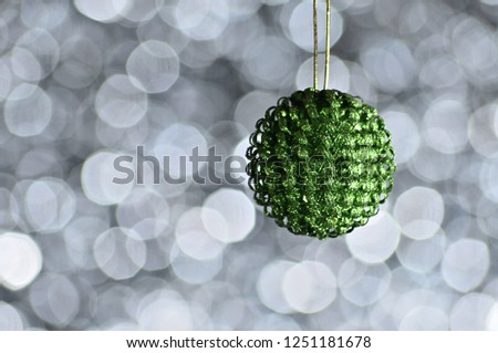 Elegant colored New Year and Christmas ball on the background with light effect and bokeh.Green,white,silver
