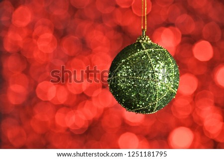 Elegant colored New Year and Christmas ball on the background with light effect and bokeh.Orange,green.