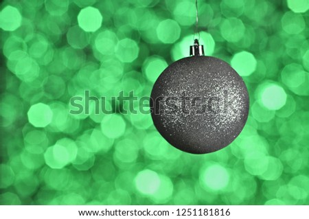 Elegant colored New Year and Christmas ball on the background with light effect and bokeh.Silver,green.