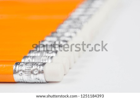 orange pencils with rubber washers on a white background
