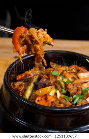 Rise with meat in korean cuisine on wood table with chopsticks asian food