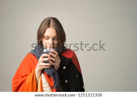 Winter girl drinking tea or coffee to warm up.