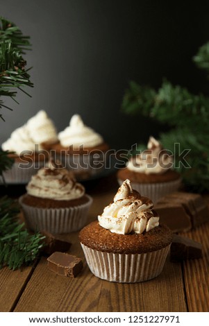 Chocolate cupcakes with whipped cream on rustic wooden table. Vertical image. 