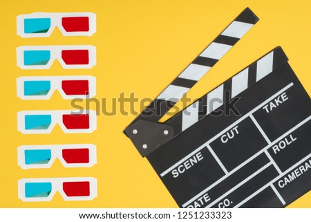 3d glasses in vertical row and clapperboard isolated on yellow