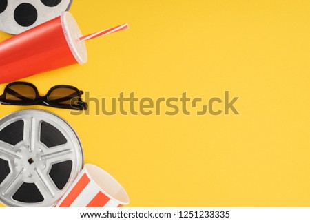 film reels, 3d glasses, popcorn bucket and red disposable cup with straw isolated on yellow