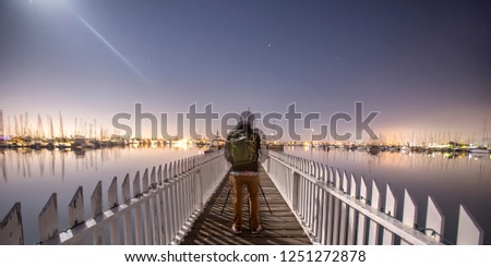 Man on a bridge with view of harbor in Point Loma