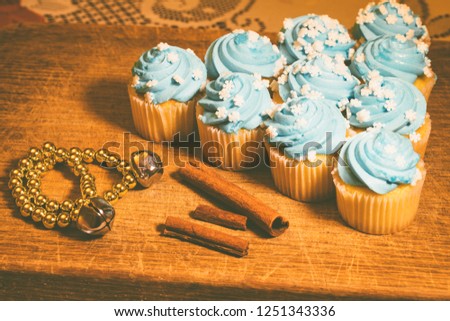 Series of Blue Frosted Cupcakes arranged with Holiday Decorations