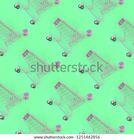 Shopping addiction, shopping lover or shopaholic concept. Many small empty shopping carts perform a pattern on a pastel colored paper background. Flat lay composition, top view
