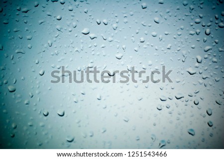 Difficult, incomprehensible, original and interesting texture, pattern and background of transparent glass with drops of water from the rain on the surface of the glass.