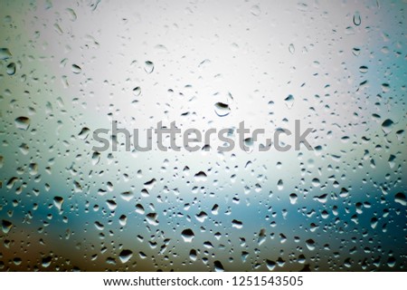 Difficult, incomprehensible, original and interesting texture, pattern and background of transparent glass with drops of water from the rain on the surface of the glass.