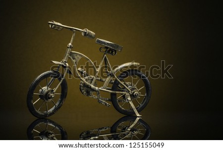 Model of bronze vintage bike on a sepia/brown background