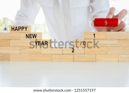 Newyear 2019 concept. Young woman building 2019 concept with wooden blocks.