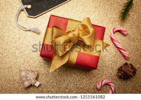 Christmas gift with deco on a golden Background merry christmas, from above, top view
