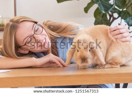 beautiful young girl and her pet rabbit at home