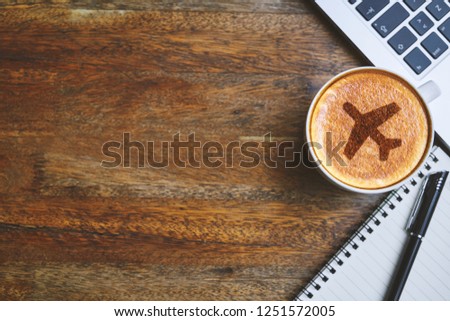 Coffee mug with Airplane web icon, laptop, notepad and pen on rustic table