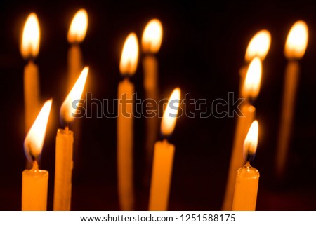 Group of burning candles in temple with shallow depth of field. Close-up. Free space.