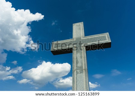 marble cross, blue sky and clouds