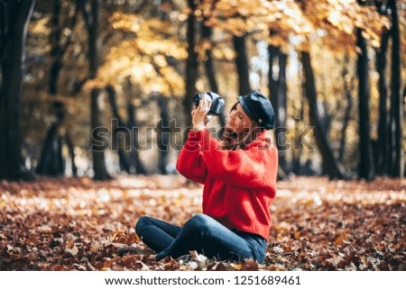 Young woman having fun with camera making photos at green park